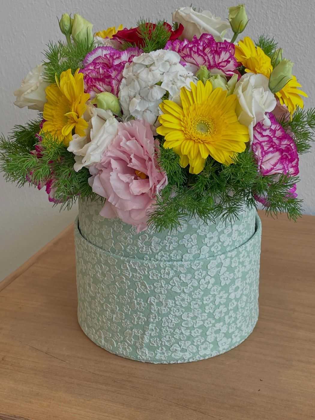 Cappelliera verde salvia con gerbere gialle e fiori rosa